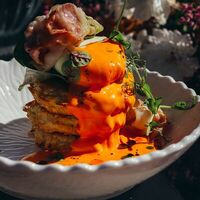 Оладьи картофельные с соусом чеддер, беконом и яйцом пашот в Лаверна