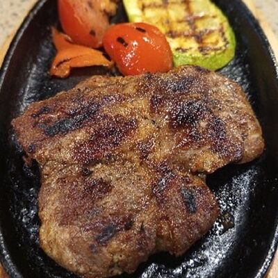 Шипящий стейк с овощами в Friday по цене 690 ₽