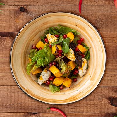 Салат с печеной тыквой, сливочным сыром и облепиховой заправкой в Деда хинкали по цене 680 ₽