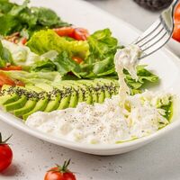 Большой салат со страчателлой. авокадо, томатами, зеленью и травяным маслом в АндерСон