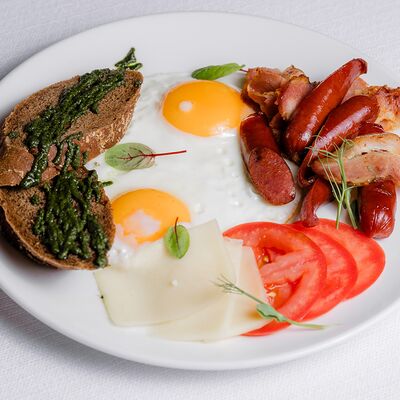 Английский завтрак с беконом, охотничьими колбасками, свежей зеленью и овощами в Ресторан Европа по цене 590 ₽