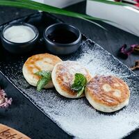 Сырники с брусничным соусом и сезонными ягодами в Benny Kitchen