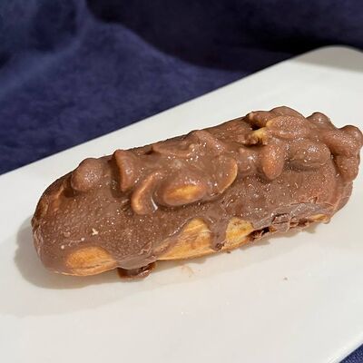 Шоколадный эклер с арахисом в Кафе сон у моря по цене 150 ₽