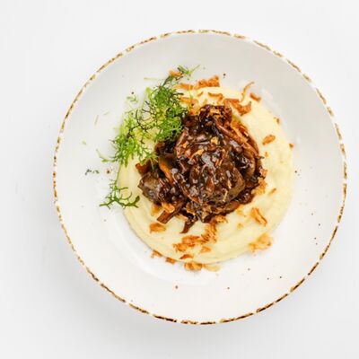 Томленые говяжьи щечки в перечном соусе с картофельным пюрев Бублик по цене 830 ₽