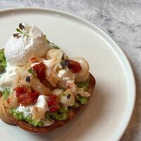 Бриошь с креветкой, битым авокадо и страчателлойв u.bistro