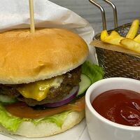 Бургер с сочной мясной котлетой, картофелем фри и томатным соусом в Кафе Сирень