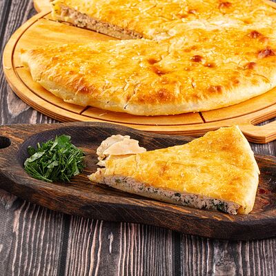 Пирог с курицей и зеленьюв Осетинские Пироги по цене 1250 ₽