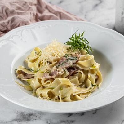 Фетучини Карбонара с беконом в сливочном соусе и сыром пармезан в Патис по цене 690 ₽