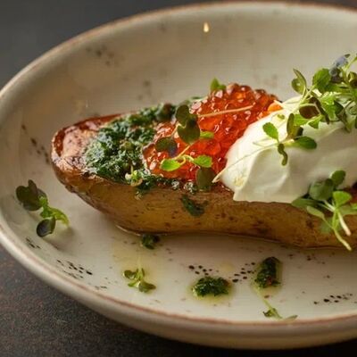 Запеченный картофель с соусом чимичурри, красной икрой и сметаной в MeatBarrique по цене 840 ₽