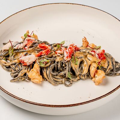 Черные спагетти с крабом и креветками в Гарда бар по цене 990 ₽