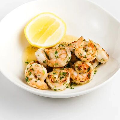 Обжаренные креветки с чесночным маслом и зеленью в Гости по цене 790 ₽