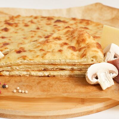 Осетинский пирог с ветчиной, шампиньонами и сыром в Осетинские пироги 22 по цене 1130 ₽