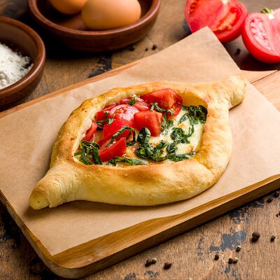 Хачапури аджарский с томатами и базиликом в Тбилисоба по цене 780 ₽