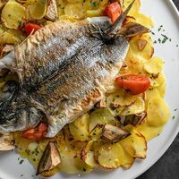 Дорадо, запеченный с картофелем и овощами в Sea-Тория