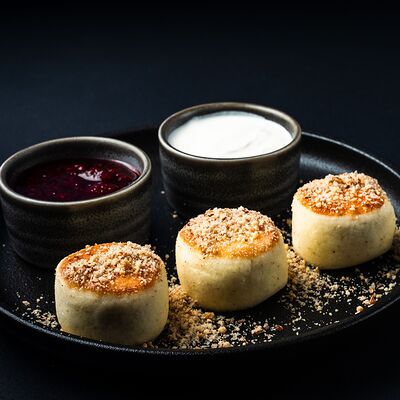 Сырники с миндальным пралине и малиновым джемом в Два веселых гуся по цене 620 ₽