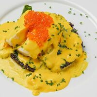 Запеченный палтус счерным ризотто, шафрановым соусом и красной икрой в Romano