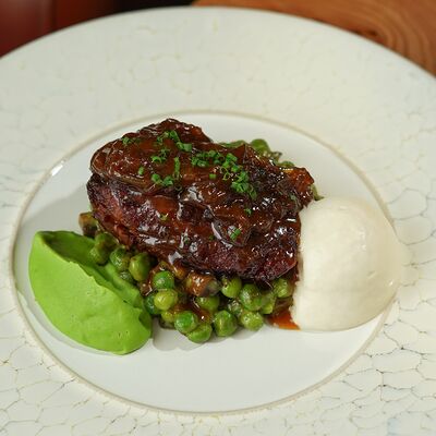 Телячья щека, томлённая в квасе с жемчужным луком, тушенным в хересе и молодым зеленым горошком в Yale по цене 1300 ₽