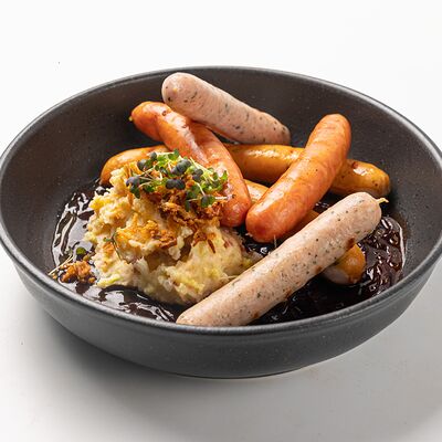 Ассорти колбасок с картофелем Colcannon и луковым соусом порто в Финнеганс по цене 990 ₽